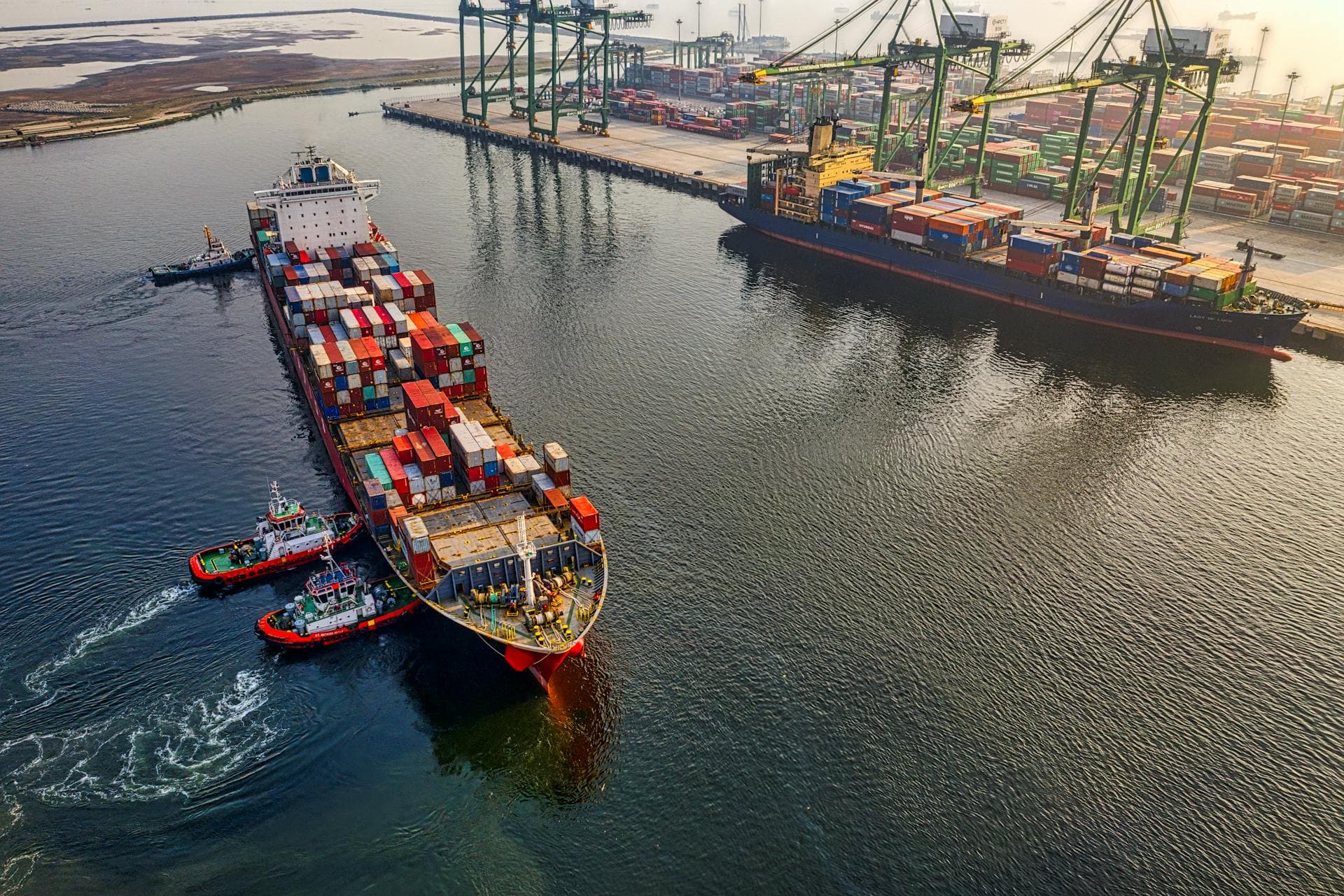 Aerial view of container ship with tugboats — Infinity Logistics freight operations