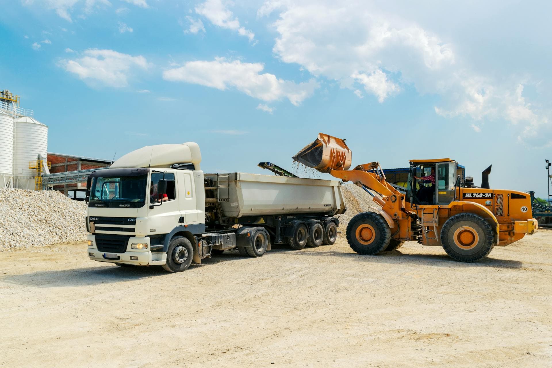 Loader filling truck with construction materials — Infinity Logistics construction materials handling