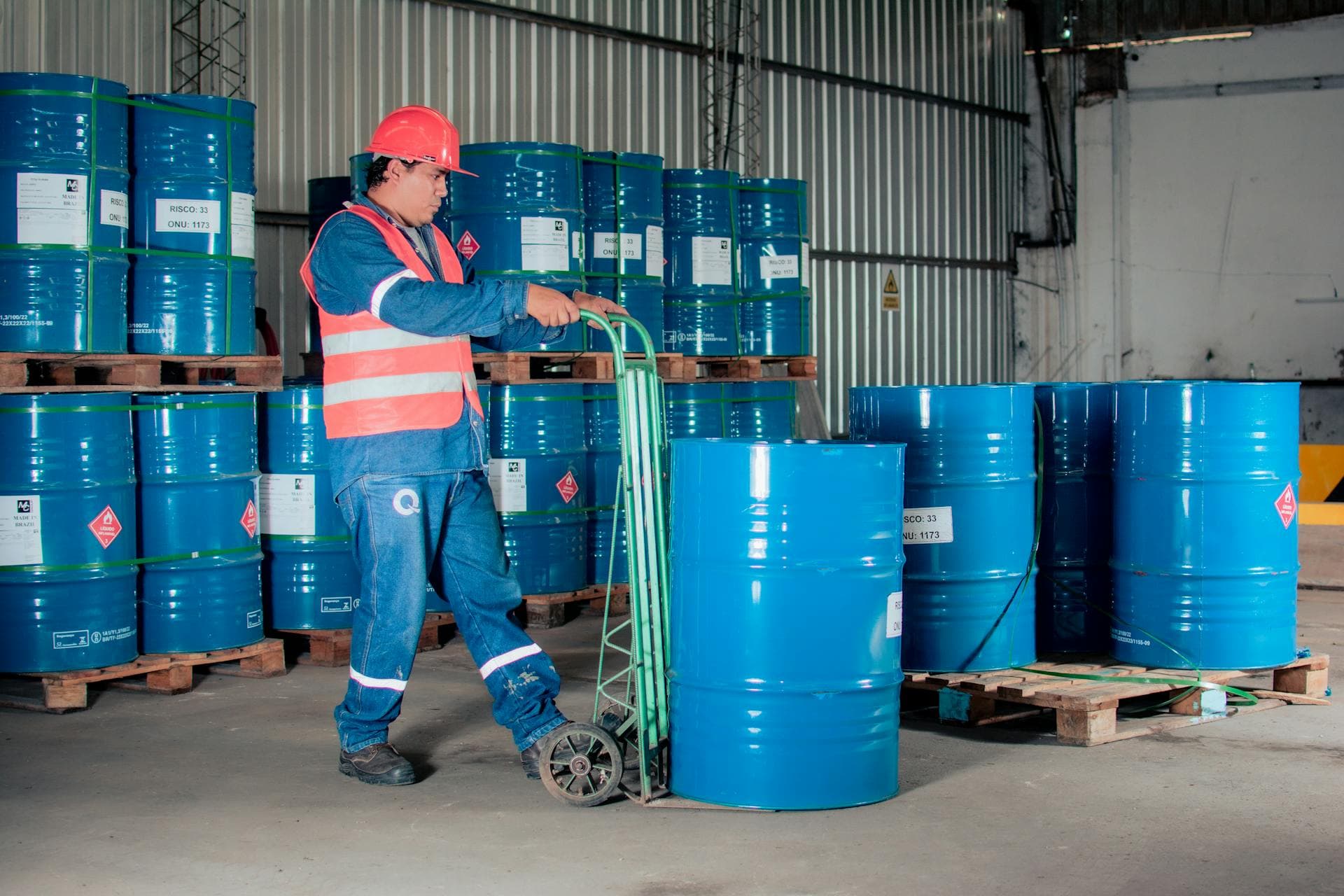 Worker moving chemical drums in warehouse operations — Infinity Logistics dangerous goods expertise